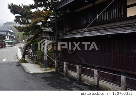 日本岐阜縣的春天。高山市中心的老城區景觀。具有歷史感的日本房屋和宏偉的松樹。 日本岐阜縣的春天。高山市中心的老城區景觀。具有歷史感的日本房屋和宏偉的松樹。 120703332