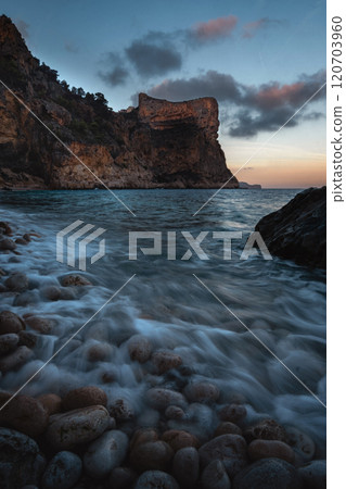 The rock rises above the blue sea at sunset or sunrise The rock rises above the blue sea at sunset or sunrise 120703960