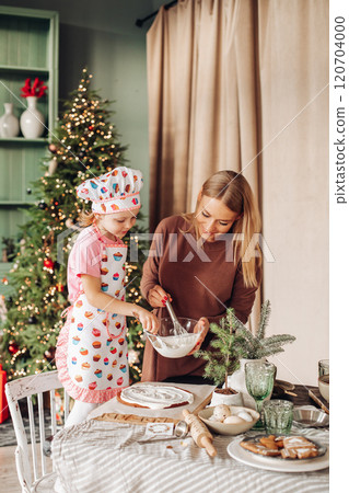 a girl child with mom in the kitchen with a 120704000