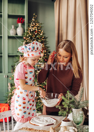 a girl child with mom in the kitchen with a 120704002