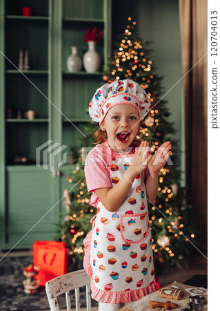 a girl child in the kitchen with a Christmas tree a girl child in the kitchen with a Christmas tree 120704013