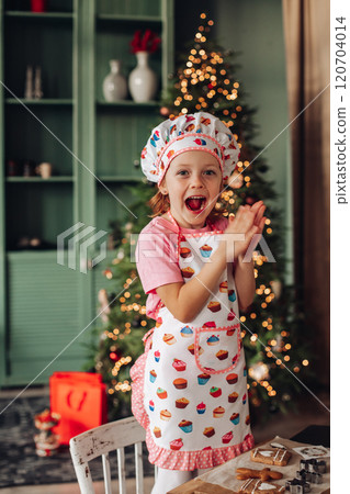a girl child in the kitchen with a Christmas tree 120704014
