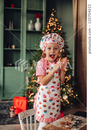 a girl child in the kitchen with a Christmas tree a girl child in the kitchen with a Christmas tree 120704015