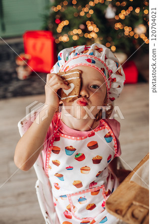 a girl child in the kitchen with a Christmas tree 120704021