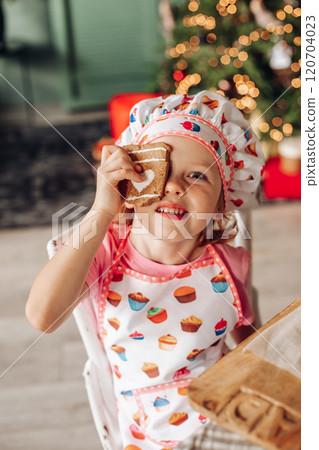a girl child in the kitchen with a Christmas tree 120704023