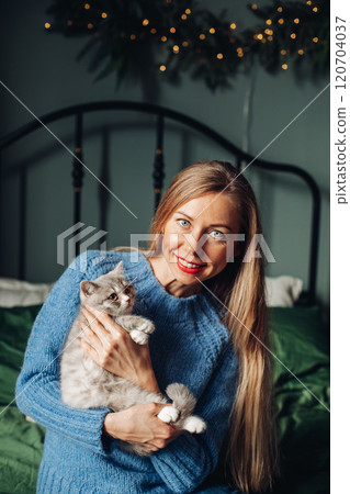 A beautiful woman at home near the Christmas tree 120704037