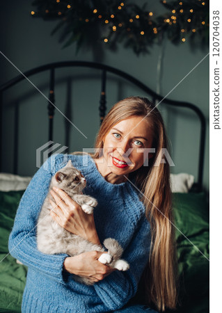 A beautiful woman at home near the Christmas tree A beautiful woman at home near the Christmas tree 120704038