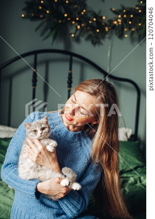 A beautiful woman at home near the Christmas tree 120704046