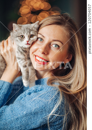 A beautiful woman at home near the Christmas tree 120704057