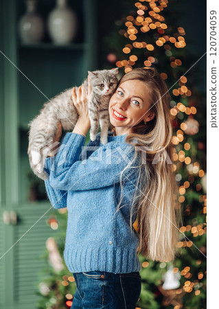A beautiful woman at home near the Christmas tree 120704059
