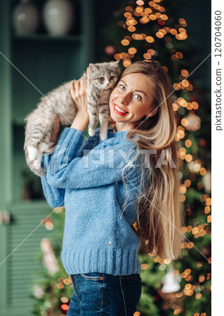 A beautiful woman at home near the Christmas tree 120704060