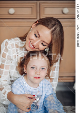 Smiling girl with mom near christmas tree at home 120704113
