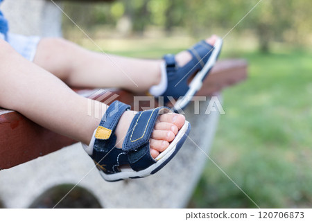 Little child wearing too small sandals. Feet are closeup, selective focus. 120706873