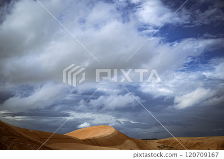 A desert landscape with a hill and a cloudy sky 120709167