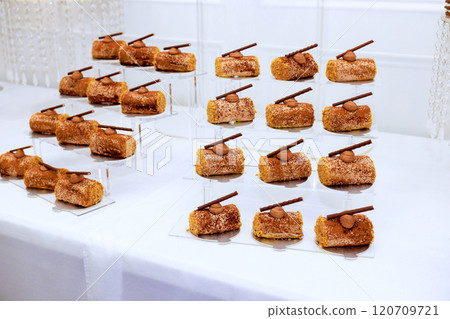 Delightful assortment of pastries is presented each featuring topping stick chocolate for at special celebratory event. 120709721
