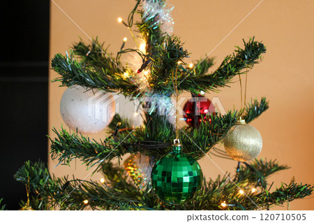 New Year's balls with garland on the top of the tree in the apartment 120710505