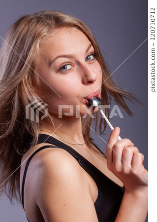 woman with a spoon in mouth woman with a spoon in mouth 120710712