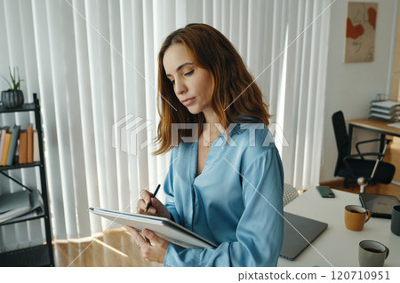 Concentrated Woman Using Tablet Device in Modern Office Concentrated Woman Using Tablet Device in Modern Office 120710951