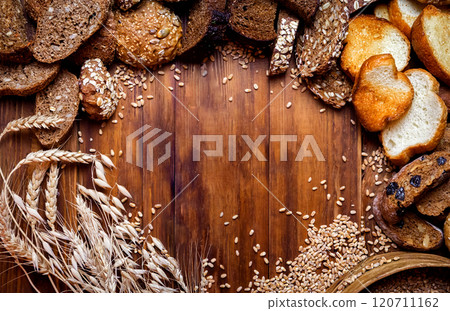 Assortment of baked bread on wooden table background Assortment of baked bread on wooden table background 120711162
