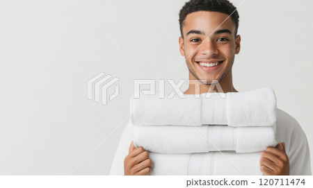 Cheerful young man holding freshly laundered towels for home and laundry concepts Cheerful young man holding freshly laundered towels for home and laundry concepts 120711474