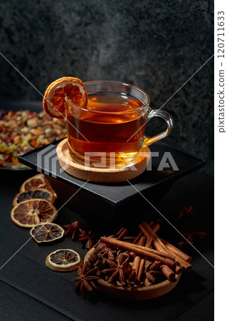 Cup of herbal tea with ingredients and slices of dried orange slices. 120711633