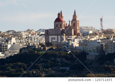 Malta, January 1, 2020: Majestic Sandstone Church Surrounded by White Houses Malta, January 1, 2020: Majestic Sandstone Church Surrounded by White Houses 120711855