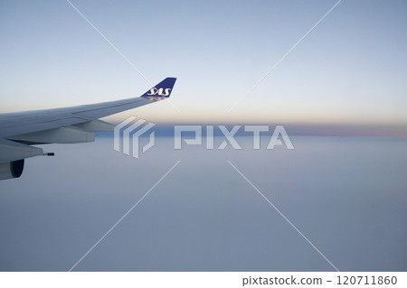 Above the Clouds, November 24, 2018: Sunset View from an Airplane Window with Long-Haul Aircraft Wing 120711860