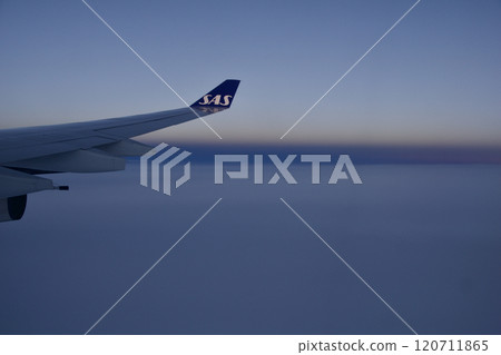 Above the Clouds, November 24, 2018: Sunset View from an Airplane Window with Long-Haul Aircraft Wing 120711865