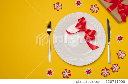 Empty white round plate, fork and knife on yellow background, top view Empty white round plate, fork and knife on yellow background, top view 120711900