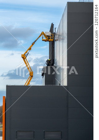 Two workers in hard hats mount elements of outdoor video advertising 120712164