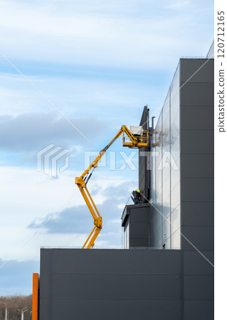Two workers in hard hats mount elements of outdoor video advertising Two workers in hard hats mount elements of outdoor video advertising 120712165