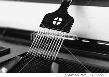 Black comb resting on a barber table in a modern grooming salon Black comb resting on a barber table in a modern grooming salon 120712200