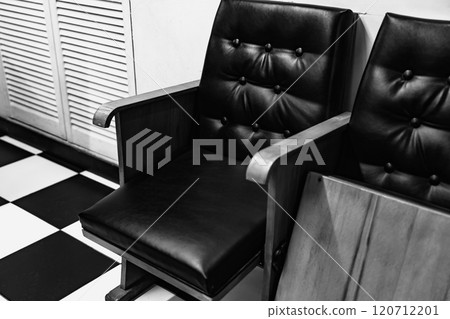 Vintage black leather chair in a retro checkered floor setting Vintage black leather chair in a retro checkered floor setting 120712201
