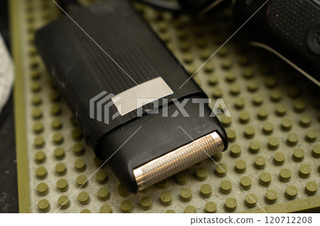 Close-up of an electric razor on a textured bathroom surface Close-up of an electric razor on a textured bathroom surface 120712208