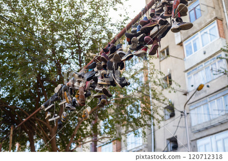 Unique display of sneakers hanging on a line in Tbilisis urban landscape 120712318