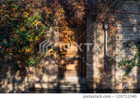 Charming autumn colors entwine a rustic door in Tbilisi, Georgias vibrant streetscape Charming autumn colors entwine a rustic door in Tbilisi, Georgias vibrant streetscape 120712340