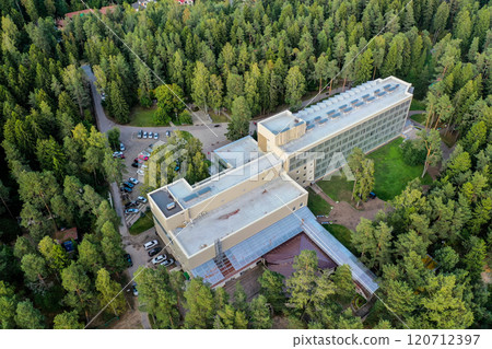 Aerial view of a modern building nestled among lush green trees in a serene forest setting 120712397