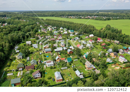 Aerial view of lush countryside village showcasing vibrant homes and green landscapes under a bright sky Aerial view of lush countryside village showcasing vibrant homes and green landscapes under a bright sky 120712412