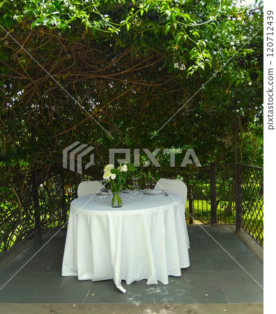 wedding arch decorated with green leaves 120712439