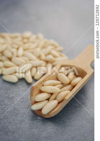 Wooden Spoon Filled with Fresh Raw Pine Nuts on Grey Background 120712692