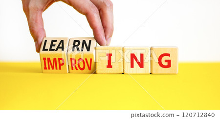 Improving or learning symbol. Businessman turns wooden cubes and changes the word Improving to Learning . Beautiful white background. Educational business improving or learning concept. Copy space. 120712840