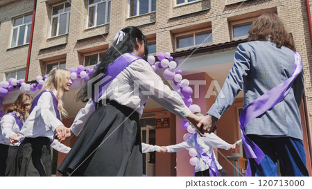 Graduates of the school twirl in a round dance holding hands. Graduates of the school twirl in a round dance holding hands. 120713000