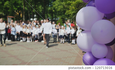 Elementary school students and teachers celebrating the last school day with purple and white balloons in the foreground Elementary school students and teachers celebrating the last school day with purple and white balloons in the foreground 120713016