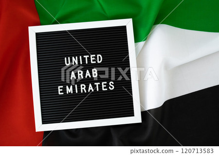 Text UNITED ARAB EMIRATES on background waving flag of UAE. National holiday, Independence Commemoration Day Muslim, congratulations. Arabian holidays. Advertisement of Dubai Text UNITED ARAB EMIRATES on background waving flag of UAE. National holiday, Independence Commemoration Day Muslim, congratulations. Arabian holidays. Advertisement of Dubai 120713583