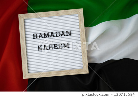 Congratulations with text RAMADAN KAREEM - happy holidays waving UAE flag on background concept. Commemoration Day Muslim Greeting card advertisement. Blessed holy month holiday Congratulations with text RAMADAN KAREEM - happy holidays waving UAE flag on background concept. Commemoration Day Muslim Greeting card advertisement. Blessed holy month holiday 120713584