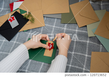 Number on craft envelopes notes with tasks before Christmas holidays. Female making kraft paper for handmade advent calendar Made with your own hands step by step DIY Number on craft envelopes notes with tasks before Christmas holidays. Female making kraft paper for handmade advent calendar Made with your own hands step by step DIY 120713652