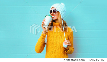 Winter portrait smiling young woman with coffee cup wearing yellow sweater, white hat Winter portrait smiling young woman with coffee cup wearing yellow sweater, white hat 120715107