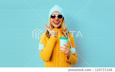 Winter portrait laughing cheerful young woman with coffee cup wearing yellow sweater, white hat 120715108