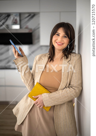 Portrait smiling business woman kitchen interior designer posing with notepad stack closeup 120715570