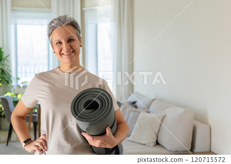 An elderly gray-haired woman is smiling at home and is planning to do yoga and exercise. An elderly gray-haired woman is smiling at home and is planning to do yoga and exercise. 120715572
